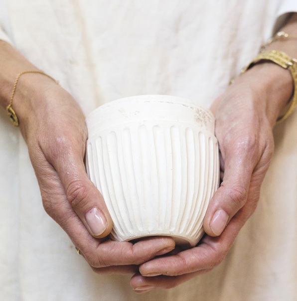 Hands holding a handmade ceramic cup